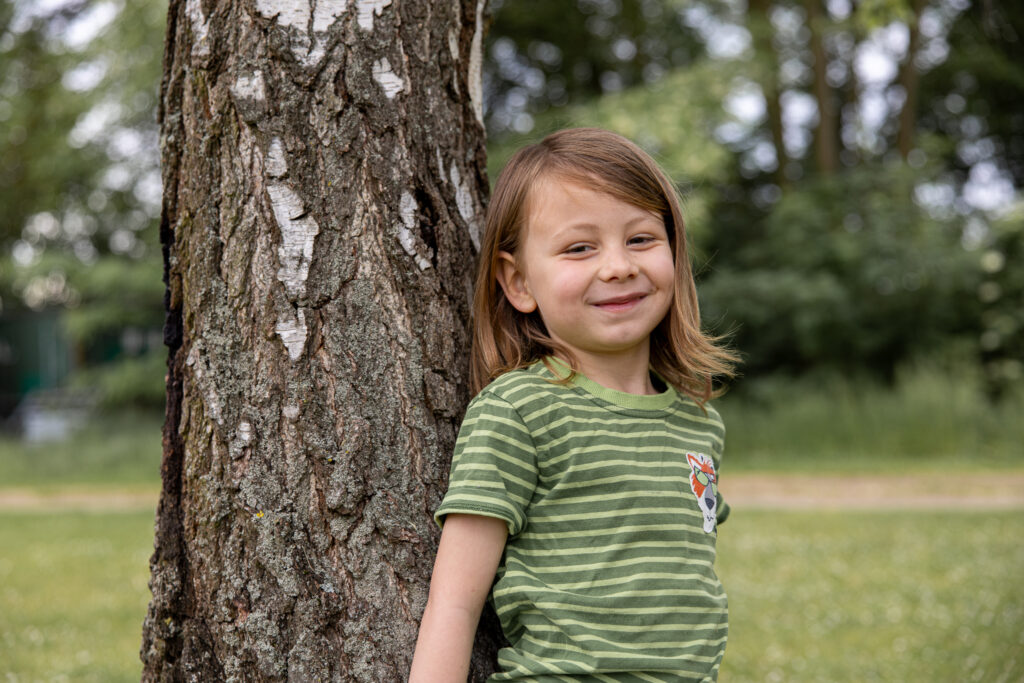 Kitakind steht am Baum