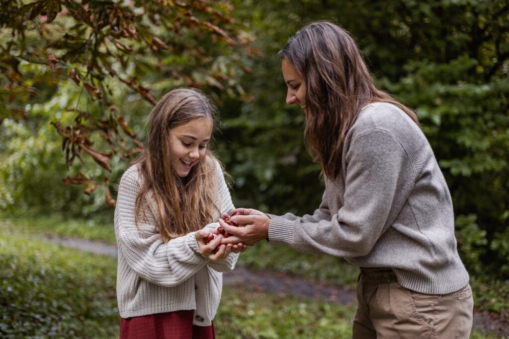 Mama und Tochter haben Kastanien in der Hand