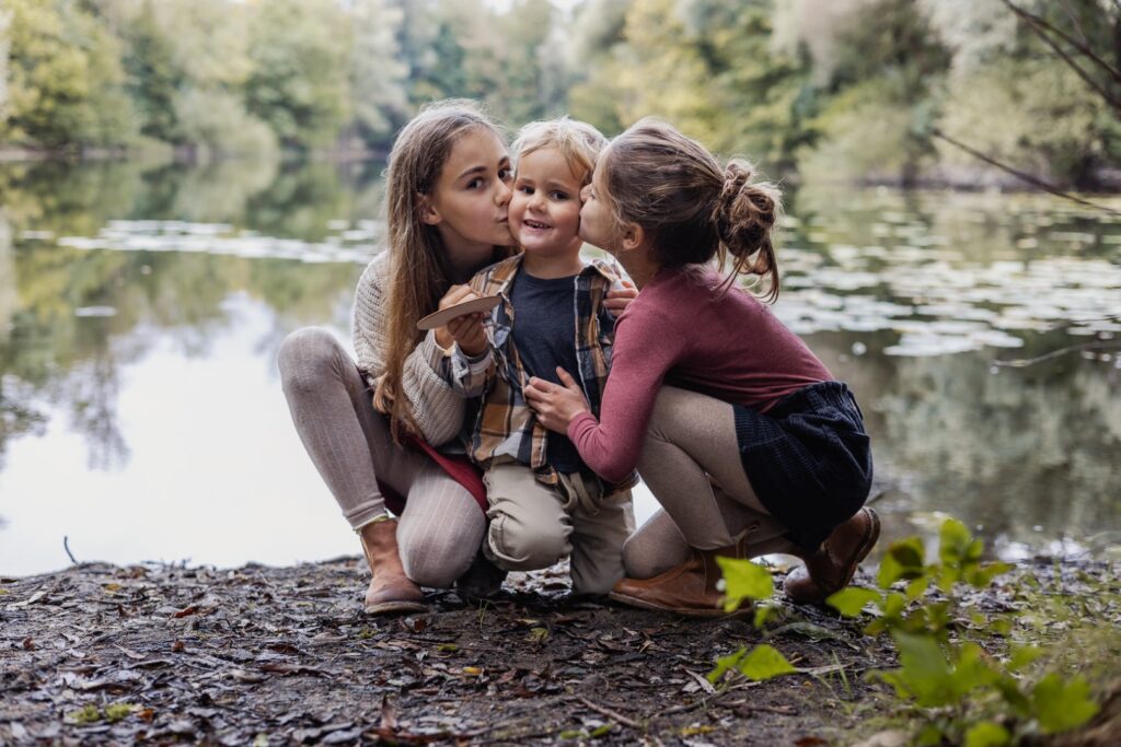 Schwestern geben ihrem Bruder einen Kuss