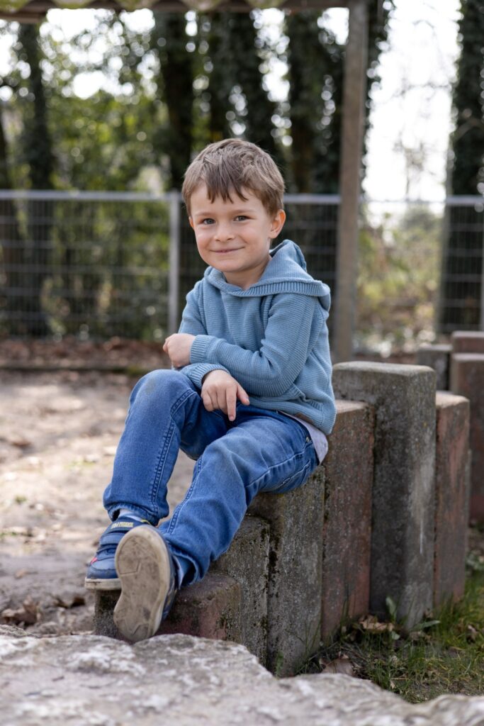 Kitakind sitzt auf Steinen und lacht