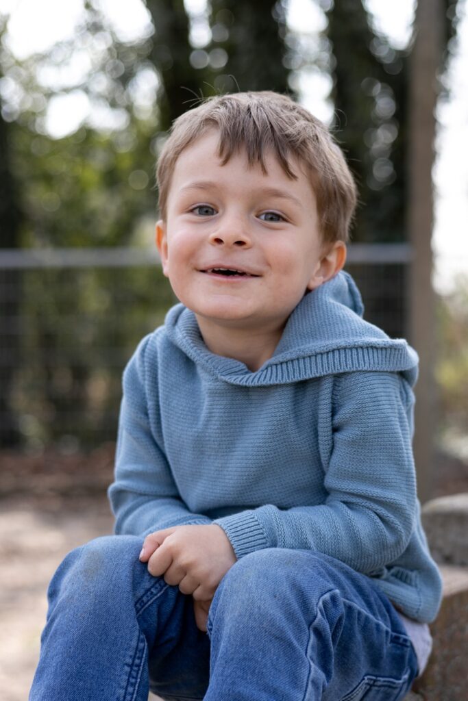 Kitakind sitzt auf Steinen und lacht