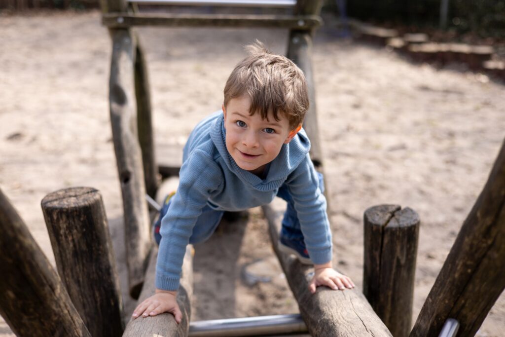 Kitakind klettert Wippe hoch