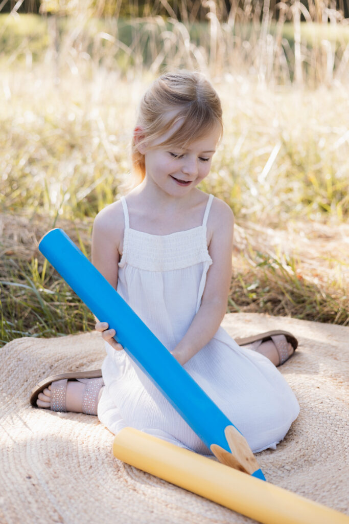 Schulkind schreibt mit übergroßem Stift in der Hand