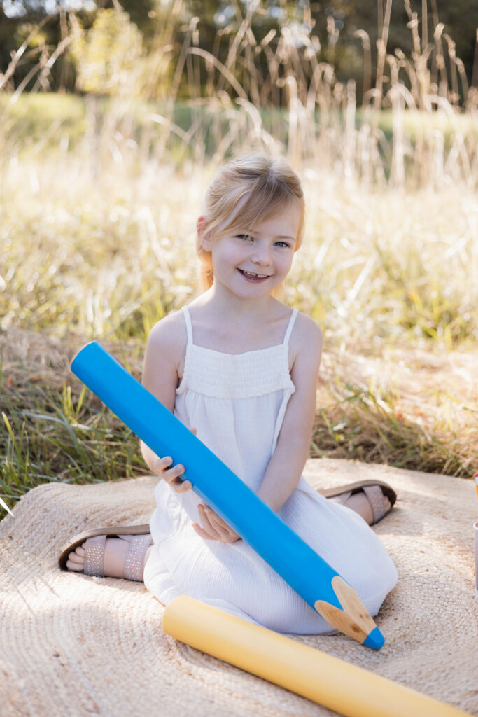 Schulkind schreibt mit übergroßem Stift in der Hand
