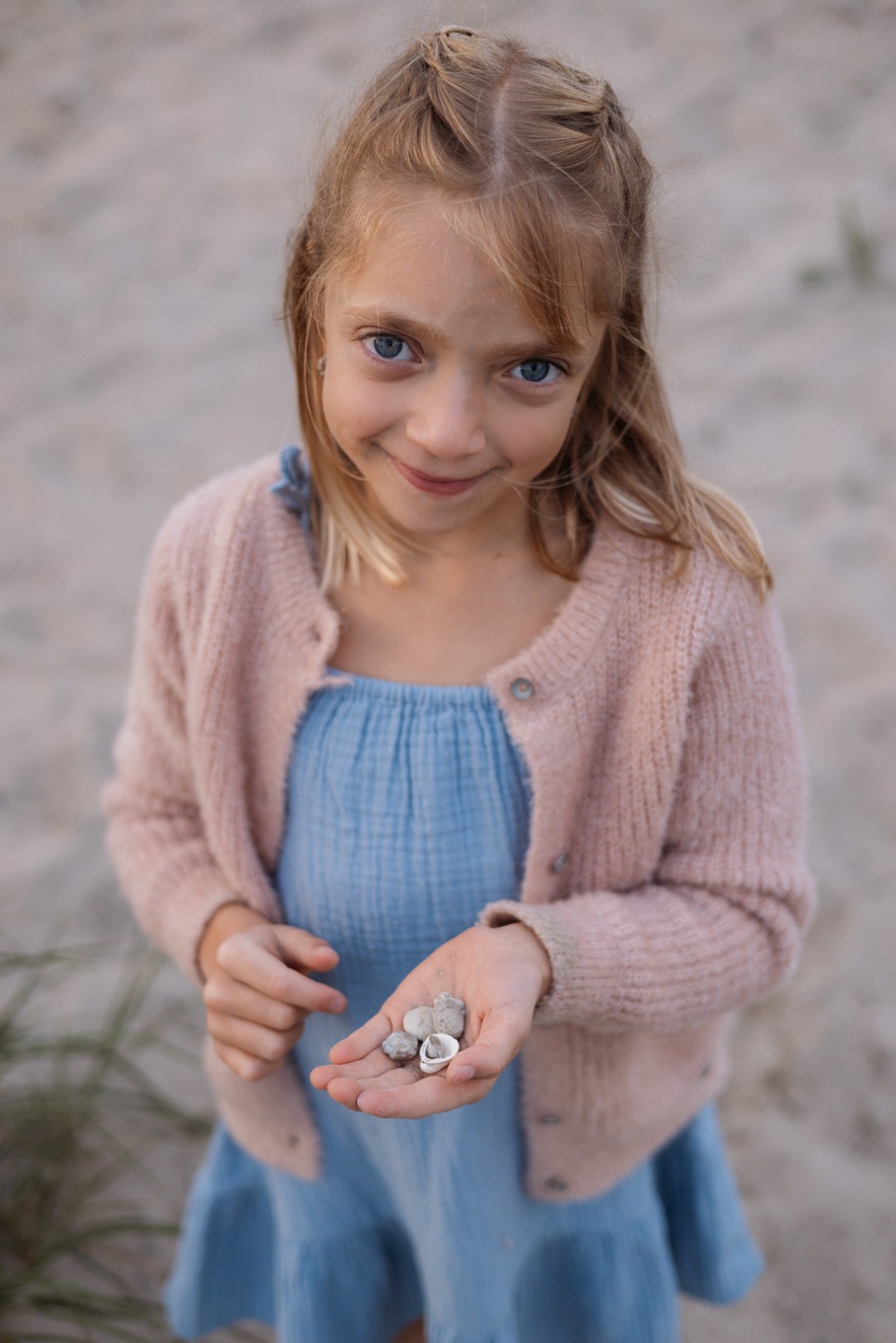 Mädchen hält in der Hand ein paar Muscheln