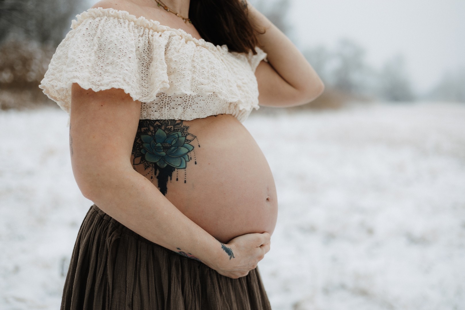 Detailbild vom nackten Babybauch im Schnee