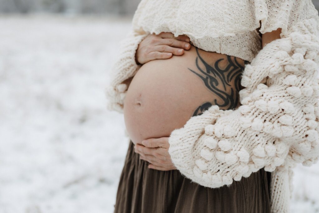 Detailbild vom nackten Babybauch im Schnee