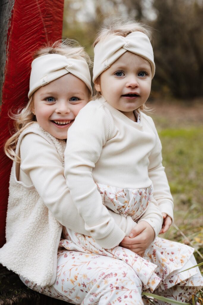 Große Schwester hat ihre kleine Schwester auf dem Schoß