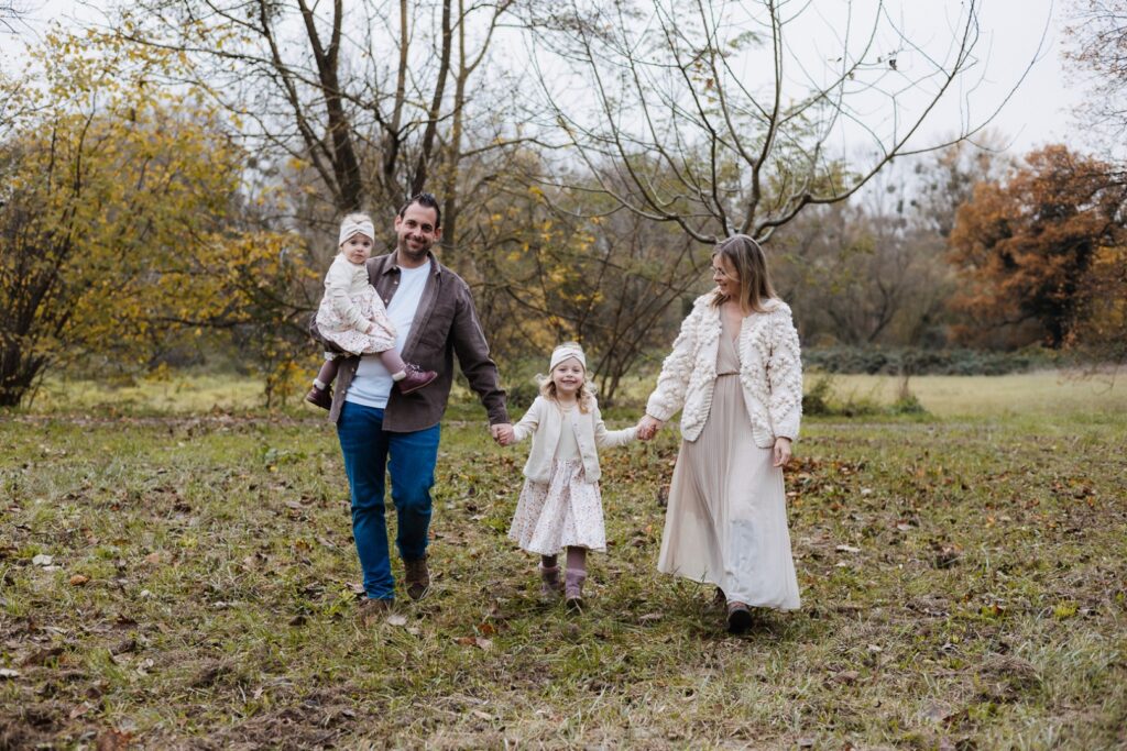 Familie läuft Hand in Hand über die Wiese