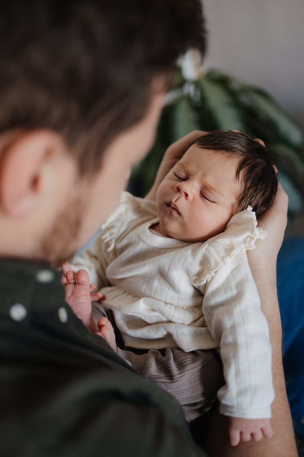 Papa hält sein Baby im Arm und schaut es an