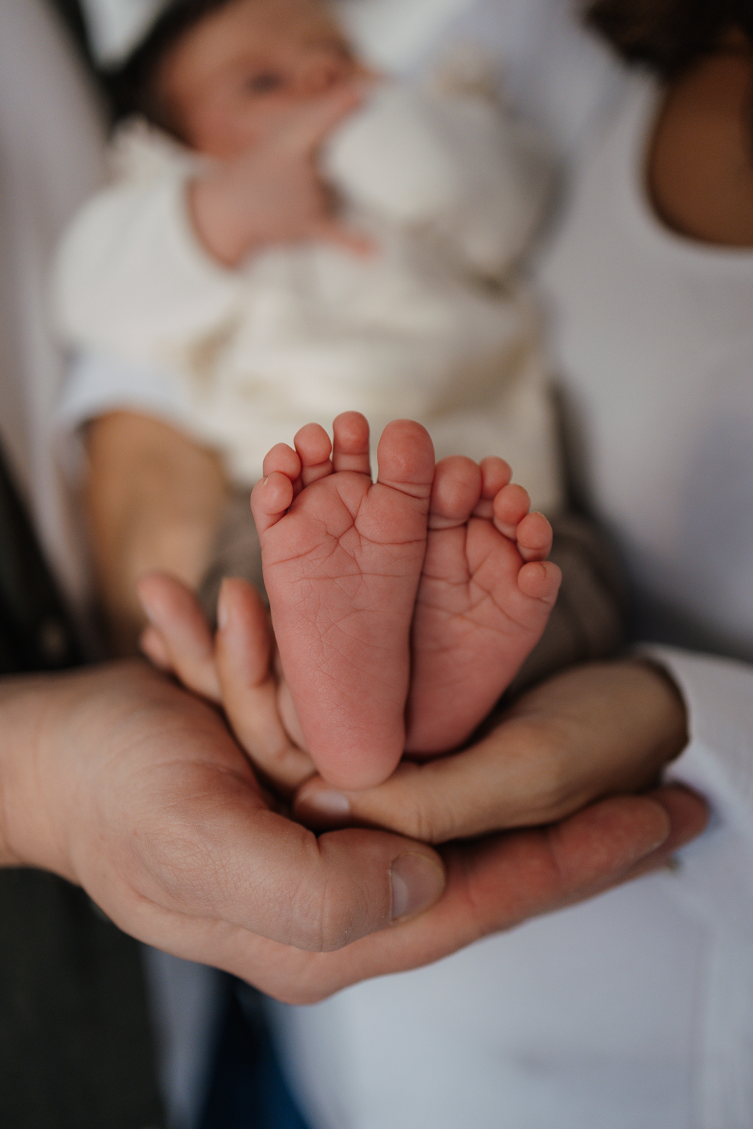 Eltern alten ihr Baby und zeigen die Babyfüße zur Kamera