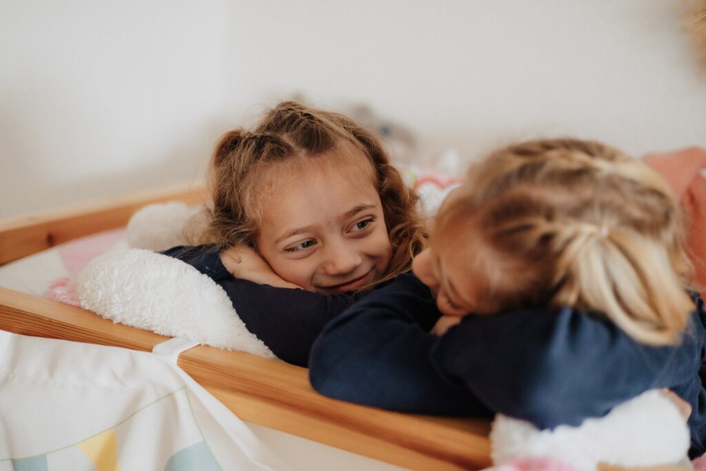 Zwei Schwestern schauen sich an und lachen