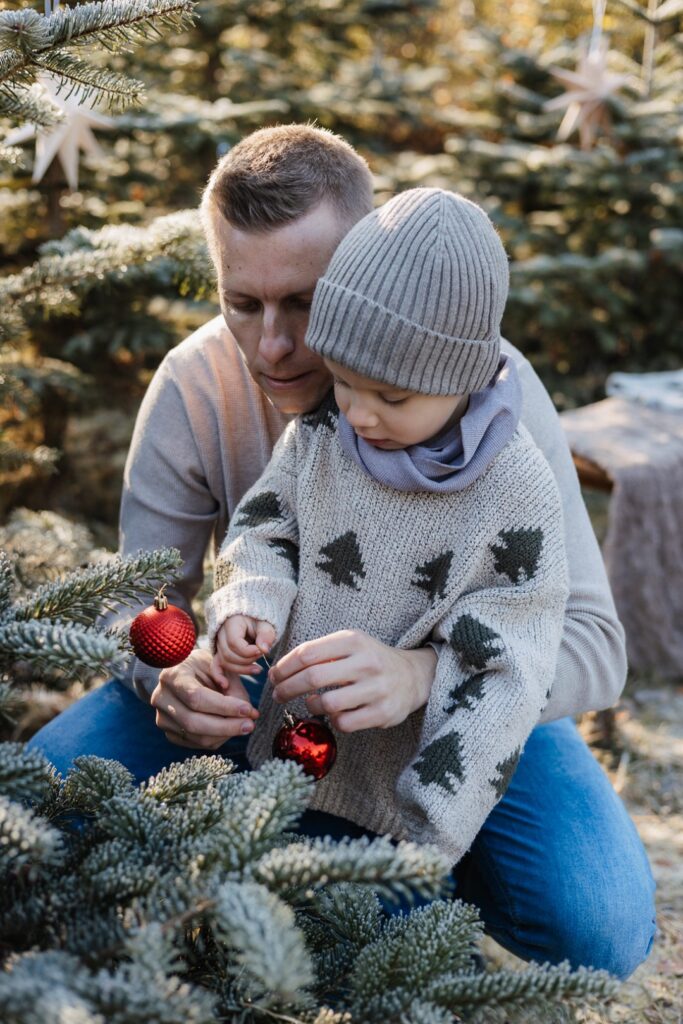 Papa und Sohn schmücken den Tannenbaum
